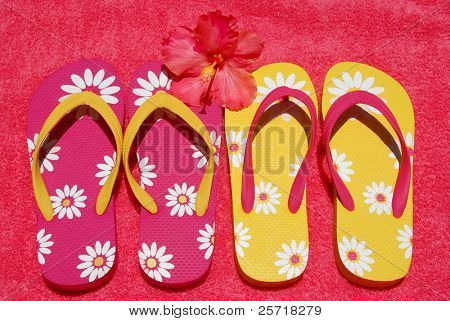 Flipflops สวยสีสันบนผ้าขนหนูกับดอกกระเจี๊ยบ