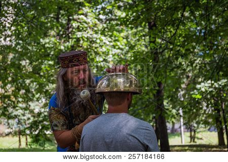 Moscow, Park On Krasnaya Presnya, August 05, 2018: A Man Makes A Massage With A Large Tibetan Singin
