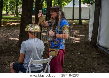 Moscow, Park On Krasnaya Presnya, August 05, 2018: A Man Makes A Massage With A Large Tibetan Singin