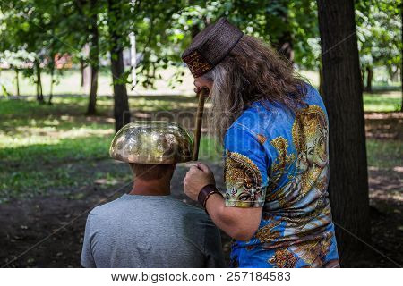 Moscow, Park On Krasnaya Presnya, August 05, 2018: A Man Makes A Massage With A Large Tibetan Singin