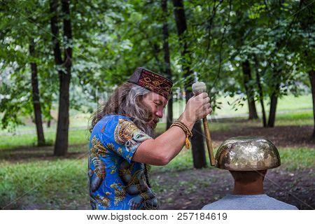 Moscow, Park On Krasnaya Presnya, August 05, 2018: A Man Makes A Massage With A Large Tibetan Singin