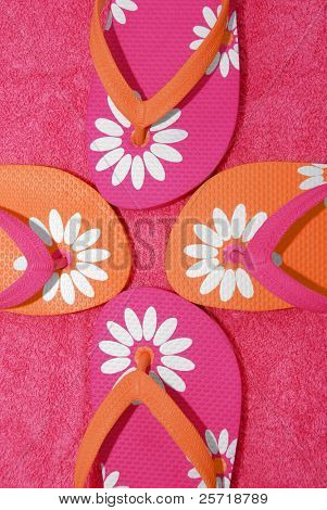 มายพริตตี้รองเท้าแตะ flipflop สีชมพู และสีส้มบนผ้าขนหนู