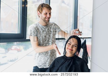 Young Woman Looking In The Mirror After Haircut.