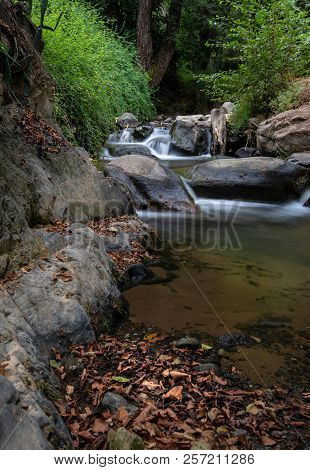 Idyllic Calm River With Small Waterfalls Flowing Between Yellow Leaves In Autumn At Kakopetria Villa