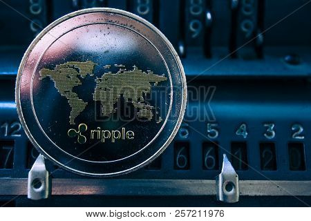 Coin Cryptocurrency Ripple On The Background Of Numbers Of The Arithmometer. The Concept Of Producti