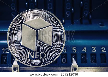 Coin Cryptocurrency Neo On The Background Of Numbers Of The Arithmometer. Concept Mining Or Neo Cour
