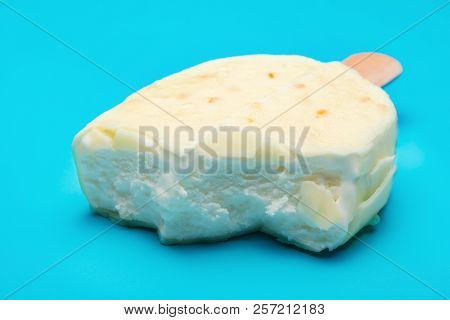 White Popsicle With Some Bites On Blue Background