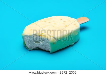 White Popsicle With A Bite On Blue Background