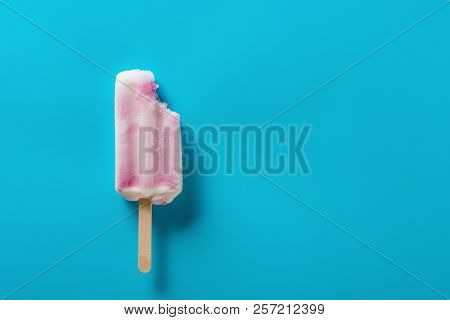 Strawberry Flavor Popsicle With A Bite On A Blue Background