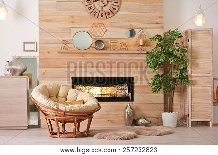 Cozy Living Room Interior With Comfortable Papasan Chair And Decorative Fireplace