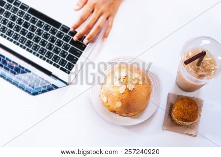 Eating Junk Food And Sweet Bread On The Computer Desk.