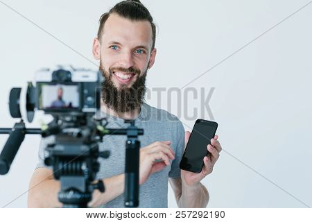 Social Media Influencer At Work. Blogger Shooting A Commercial Or Independent Review. Man Holding A 