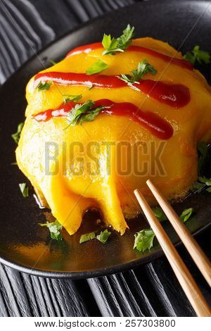 Japanese Omurice Omelette Stuffed With Rice, Chicken And Vegetables Close-up On A Plate. Vertical
