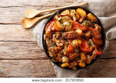 Fried Meat With Potatoes, Tomatoes, Herbs And Spices Close-up On A Frying Pan. Georgian Cuisine. Hor