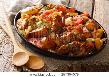 Georgian Dinner: Fried Meat With Potatoes, Tomatoes, Onions, Herbs And Spices Close-up On A Frying P