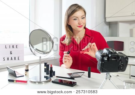 Attractive Video Blogger Looking To Camera, Holding Cosmetic Product While Giving Make Up Advices To
