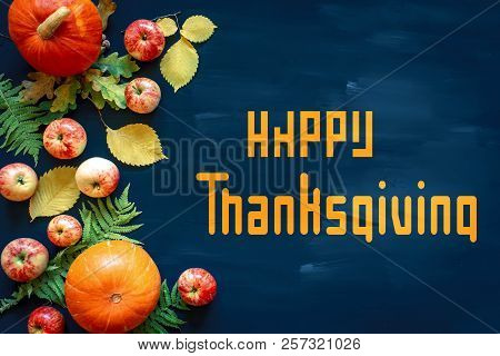 Happy Thanksgiving Text With Pumpkins And Leaves Over Dark Wood Background