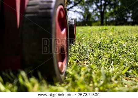 Ground Perspective View At Lawnmover In The Green Field