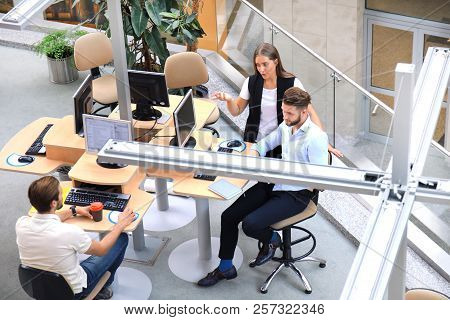 Top View Of Young Modern Colleagues In Smart Casual Wear Working Together While Spending Time In The