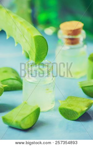 Aloe Vera Extract In A Small Bottle And Pieces On The Table. Selective Focus.
