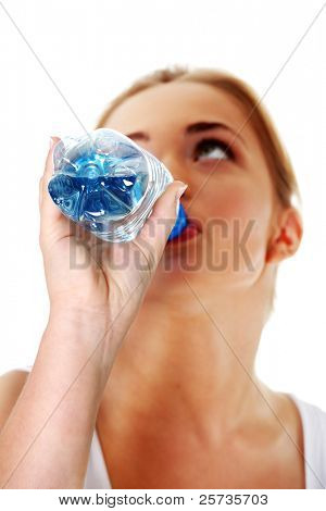 Close up di teen donna bere acqua minerale da una bottiglia. Focalizzata sulla bottiglia