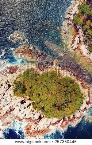 Beautiful View Of The Peninsula And A Small Rocky Island. Seaside Landscape With Coniferous Forest. 