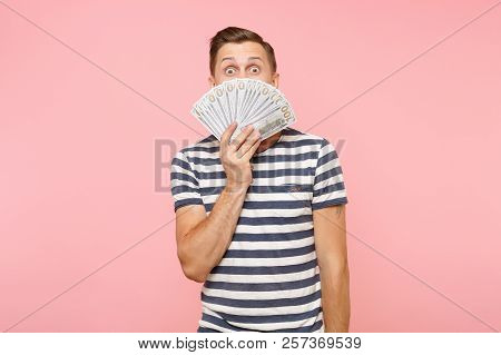 Portrait Of Young Man In Striped T-shirt Holding And Hiding Face Bundle Lots Of Dollars, Cash Money,