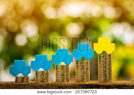 Stack Coin With Car Model With Growing On The Top For Collect Interest Put On The Wood In The Public