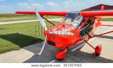 Close Up View Of Red Airplane With Propeller On Cloudy Sky Background