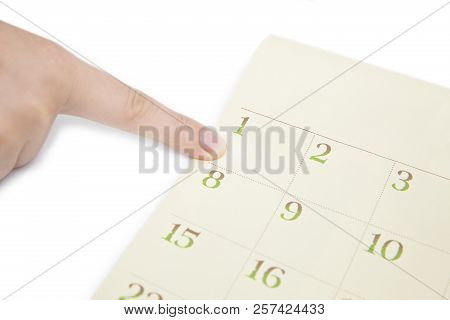 Female's Finger Showing Date In A Calendar On White Background. Number In The Calendar