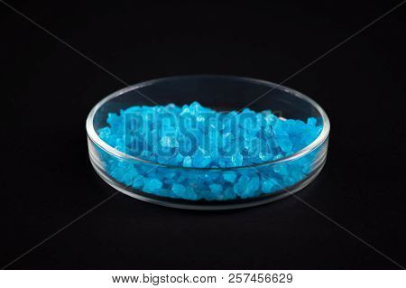 Close Up Shot  Of Blue Crystals In Petri Dish, Isolated On Black Background, Chemical Lab Concept