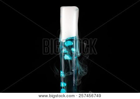 Close Up Of Test Tube With Blue Liquid With Cold Steam Pouring From It Against Black Background, Che