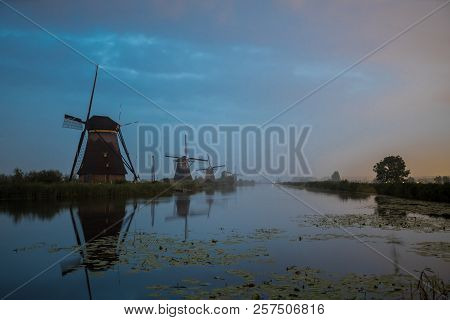 On The Water There Are Several Windmills In Kinderdijk In Holland