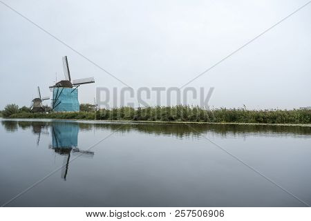 On The Water There Are Several Windmills In Kinderdijk In Holland
