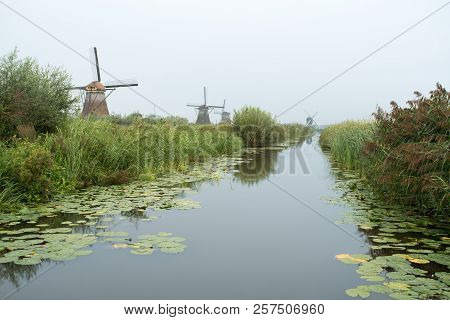 On The Water There Are Several Windmills In Kinderdijk In Holland