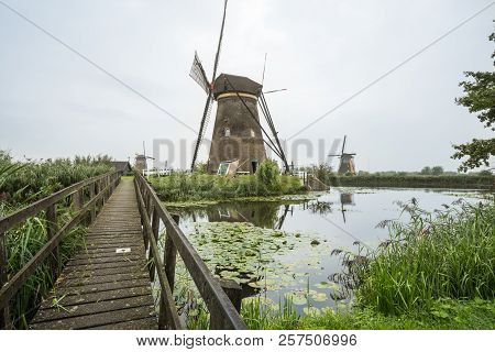 On The Water There Are Several Windmills In Kinderdijk In Holland