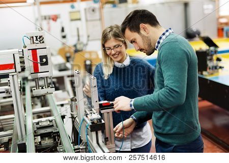 Young Attractive Students Of Mechatronics Working On Project