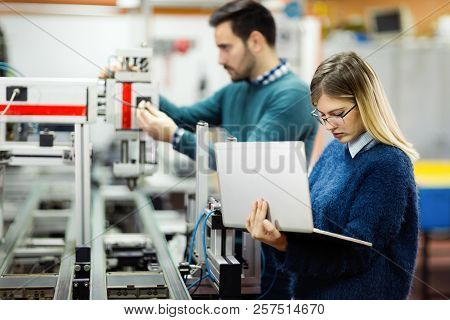 Young Attractive Students Of Mechatronics Working On Project