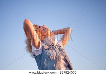 Trendy Girl With Large Headphones On Sky Background, Free Space On The Right. Portrait Of A Young Ch