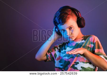 Dj Boy With Headphones Enjoys Music On Color Liht Background