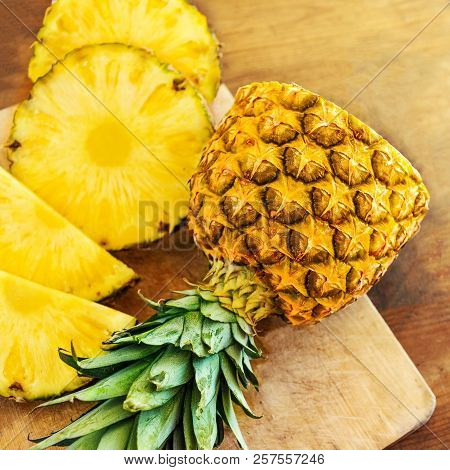 Pineapple On Wood Texture Background. Whole And Sliced Tropical Pineapple On Wooden Cutting Board  W
