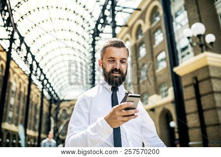Businessman With Smartphone On The Trian Station In London, Text Messaging.