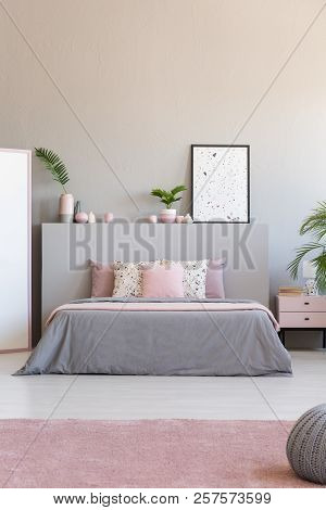 Light Grey And Pastel Pink Bedroom Interior In Real Photo With Fresh Plants, King-size Bed And Lastr