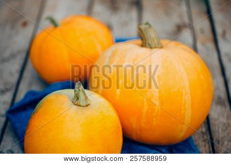 A Large Orange Pumpkin On The Blue Towel On Wooden Background. Close-up, Horizontal