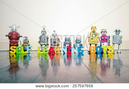  SELF LEARNING BOTS wooden letters and retro robot toys on a wooden floor with reflection