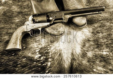 Cowboy Boots And Western Cowboy Pistol In Black And White.
