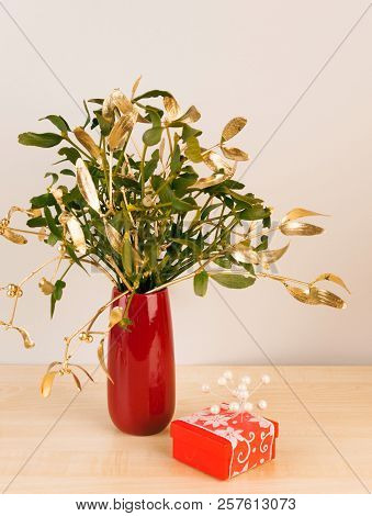 Gift In Red Package With Mistletoe In Vase