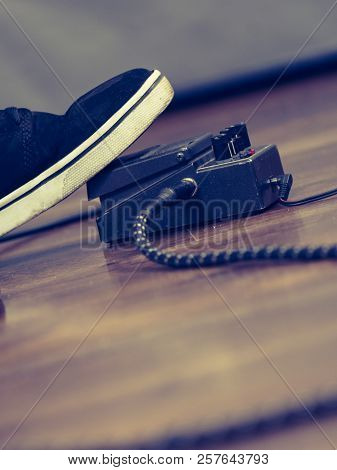 Man With Musical Instrument Setting Up Guitar Audio Stomp Box Effects And Cables In Music Studio
