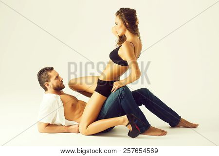 Dominance. Cute Woman Or Sexy Girl With Long Hair In Erotic, Black Bra, Shorts, High Heel Shoes Sitt