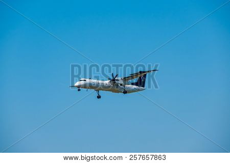 Zurich, Switzerland - July 19, 2018: Star alliance airlines Bomardier Dash 8 Q400 airplane preparing for landing at day time in international airport